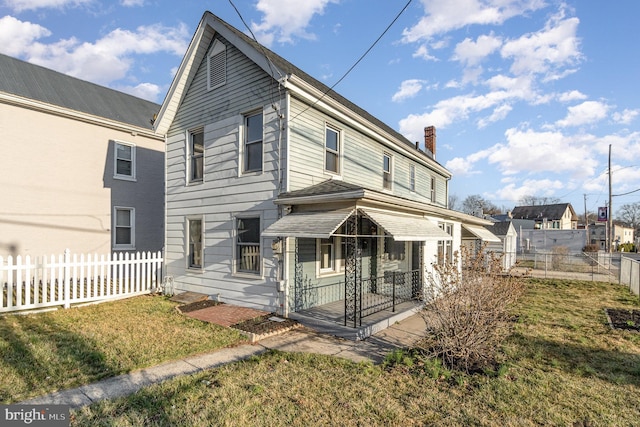 view of front of property featuring a front yard, fence, and a chimney