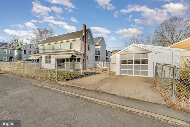 view of front of property with a fenced front yard, an outbuilding, and driveway