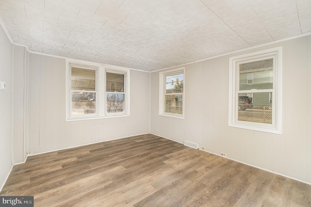 spare room with visible vents and wood finished floors