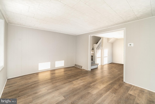 spare room with visible vents, wood finished floors, and stairway