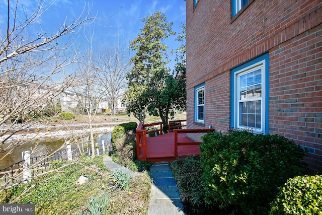 view of property exterior with a deck and brick siding