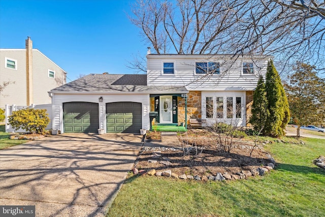 view of front of house with driveway, stone siding, an attached garage, a shingled roof, and a front yard