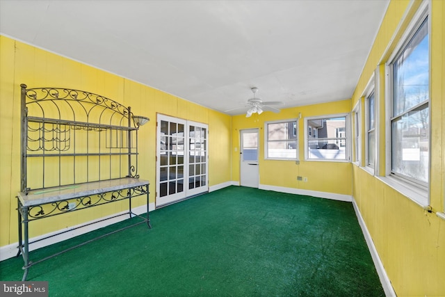 unfurnished sunroom with ceiling fan