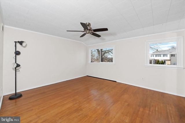 empty room featuring visible vents, a ceiling fan, wood finished floors, crown molding, and baseboards