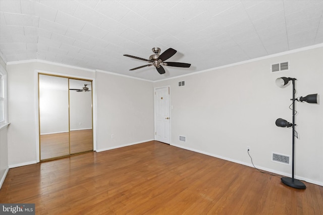 unfurnished bedroom with visible vents, wood finished floors, and ornamental molding