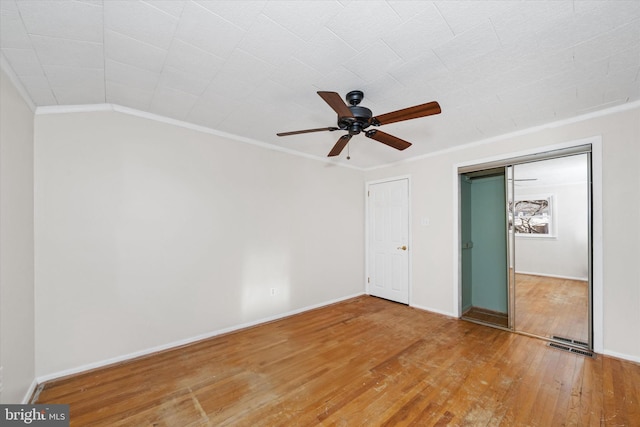 unfurnished bedroom featuring a closet, baseboards, light wood finished floors, and ornamental molding