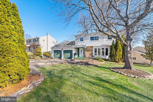 view of front of property with driveway, a front lawn, and an attached garage