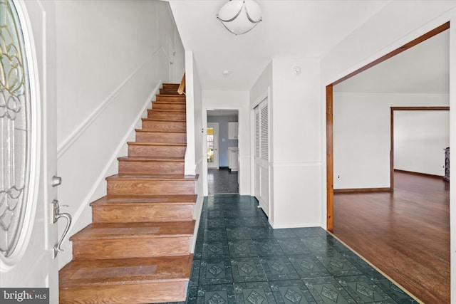 foyer with stairway and baseboards