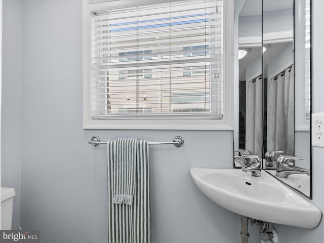 bathroom featuring a sink, plenty of natural light, and toilet