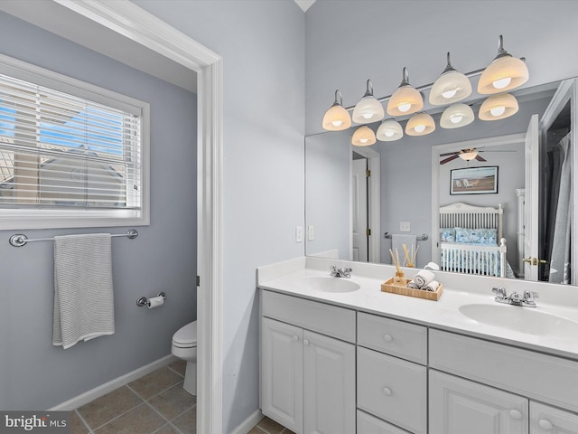 bathroom featuring a sink, toilet, double vanity, and tile patterned flooring