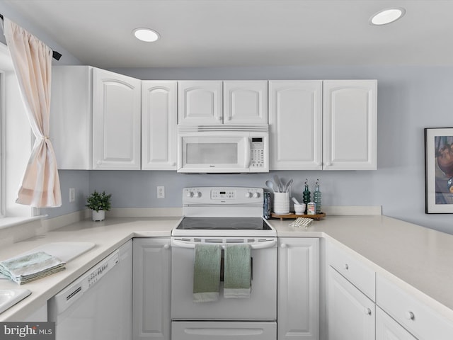 kitchen with white cabinets, white appliances, and light countertops