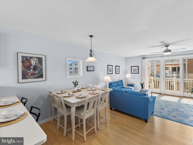 dining space featuring ceiling fan, baseboards, and light wood-style floors