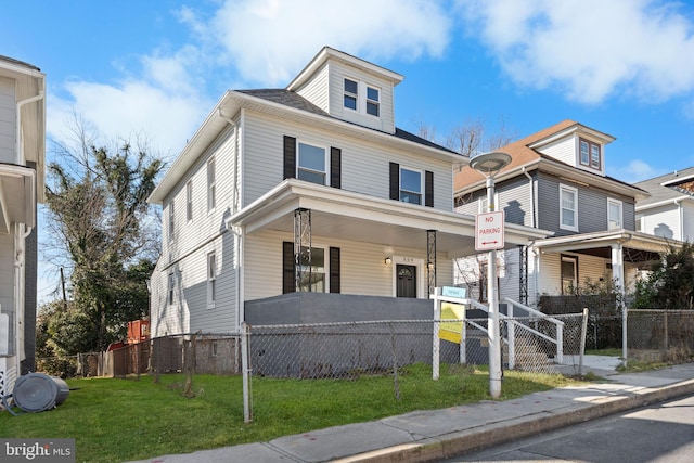 traditional style home with a fenced front yard, covered porch, and a front lawn