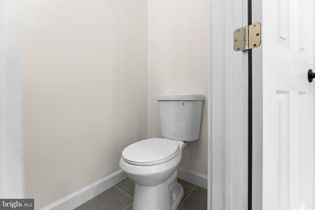 bathroom featuring tile patterned flooring, toilet, and baseboards