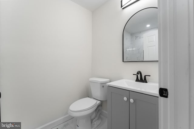 bathroom featuring marble finish floor, toilet, vanity, and baseboards