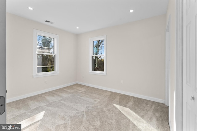 carpeted empty room with a wealth of natural light, visible vents, baseboards, and recessed lighting