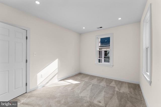 spare room with carpet flooring, recessed lighting, visible vents, and baseboards