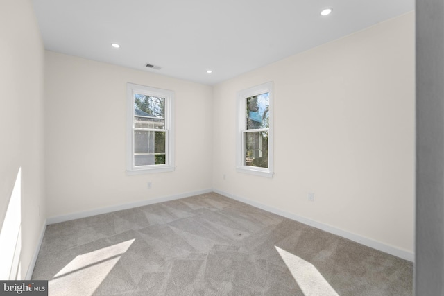 carpeted spare room featuring recessed lighting, visible vents, and baseboards