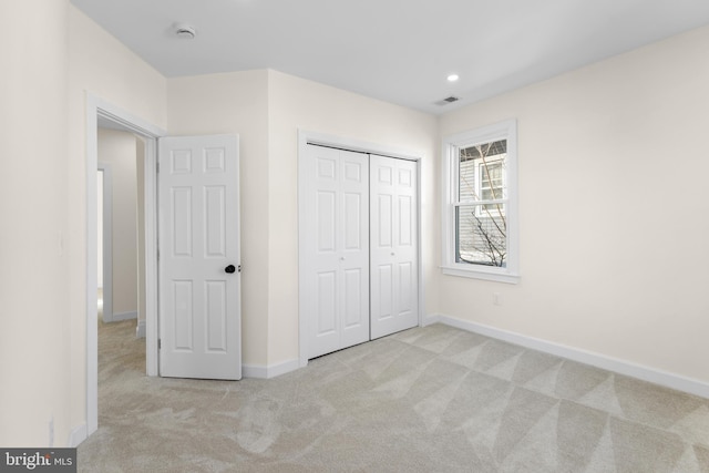 unfurnished bedroom featuring recessed lighting, a closet, baseboards, and carpet flooring