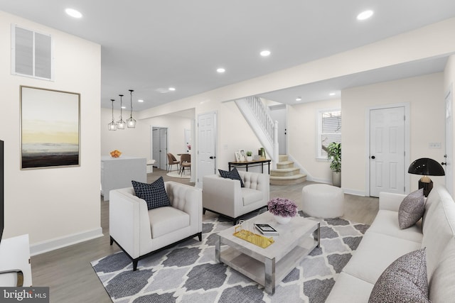 living area featuring recessed lighting, visible vents, wood finished floors, and stairs