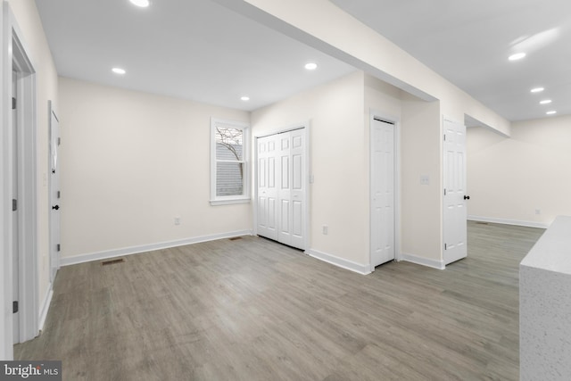 interior space with visible vents, recessed lighting, wood finished floors, and baseboards