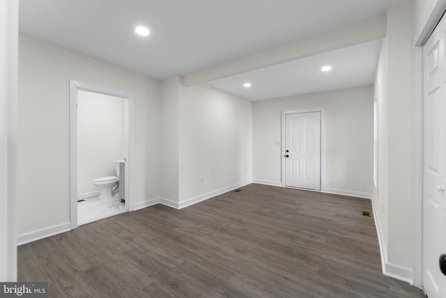 interior space featuring recessed lighting, dark wood-type flooring, and baseboards