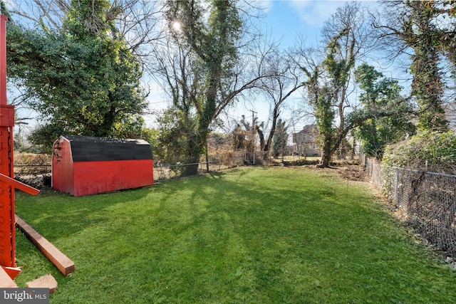 view of yard with an outdoor structure, a fenced backyard, and a shed