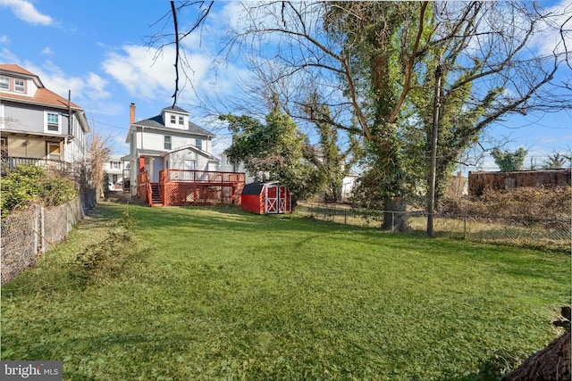 view of yard with a fenced backyard, a storage unit, and an outdoor structure