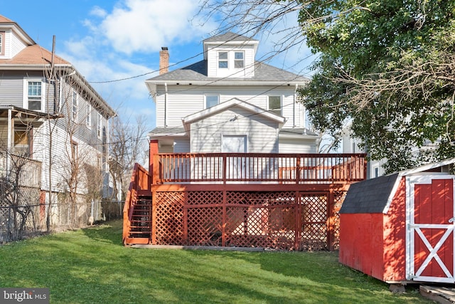 back of property featuring a storage shed, a lawn, an outdoor structure, and a wooden deck