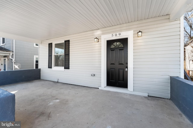 view of exterior entry with a patio area