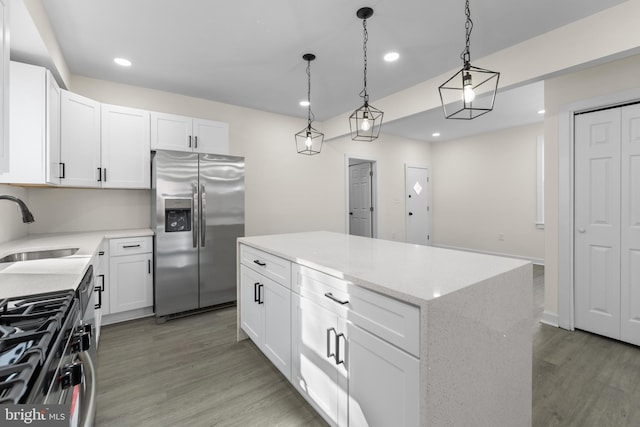 kitchen with a center island, stainless steel appliances, light wood-type flooring, and a sink