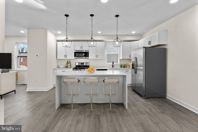 kitchen with a kitchen island, stainless steel appliances, dark wood-type flooring, and a sink