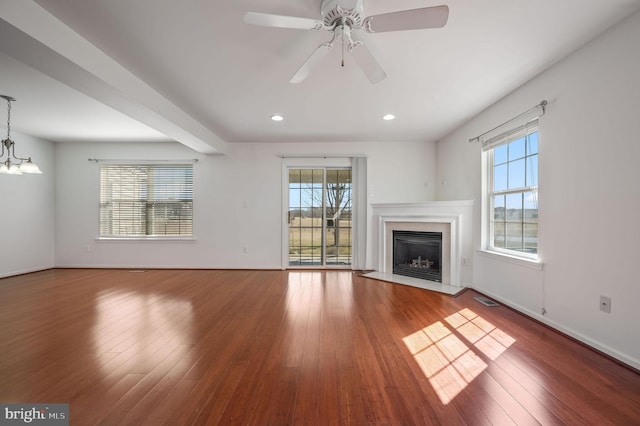 unfurnished living room with hardwood / wood-style floors, a fireplace, and a healthy amount of sunlight