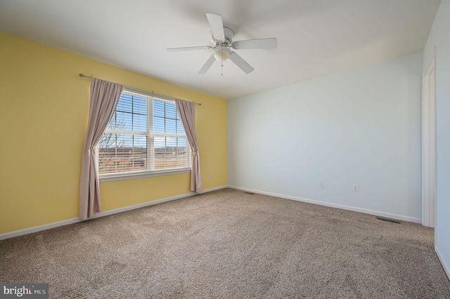 spare room with a ceiling fan, baseboards, and carpet floors