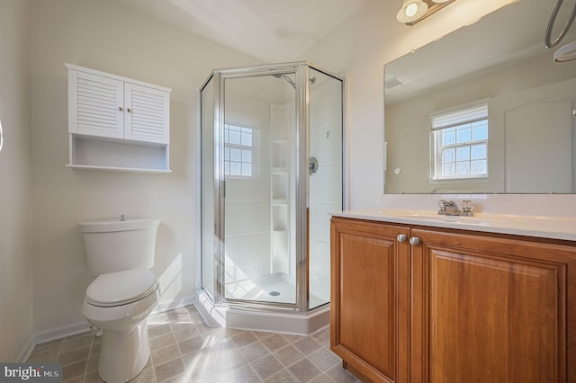 bathroom with a stall shower, toilet, and vanity