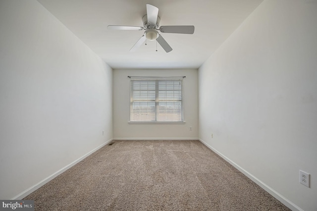 empty room featuring a ceiling fan, baseboards, and light carpet