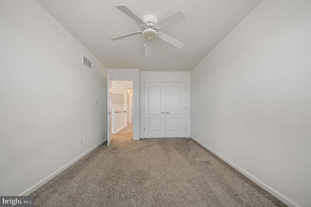 unfurnished bedroom featuring visible vents, a closet, carpet floors, baseboards, and ceiling fan