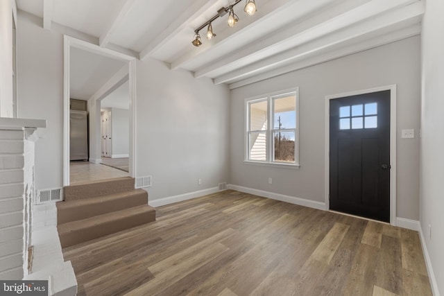 foyer featuring beamed ceiling, baseboards, visible vents, and light wood-type flooring