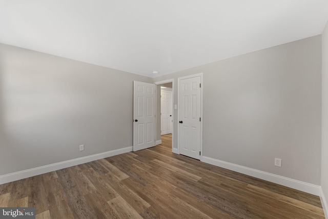 empty room with baseboards and wood finished floors