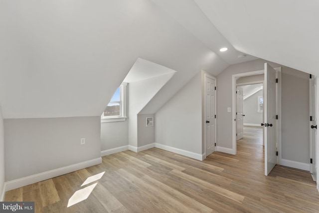 additional living space with recessed lighting, lofted ceiling, baseboards, and wood finished floors