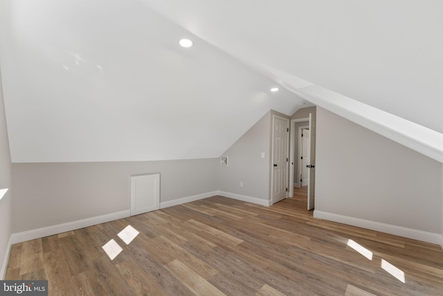 bonus room featuring vaulted ceiling, wood finished floors, and baseboards