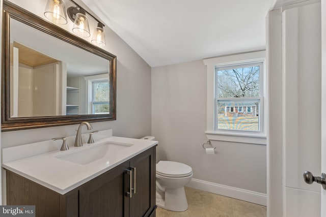 half bathroom with vanity, toilet, baseboards, and a wealth of natural light