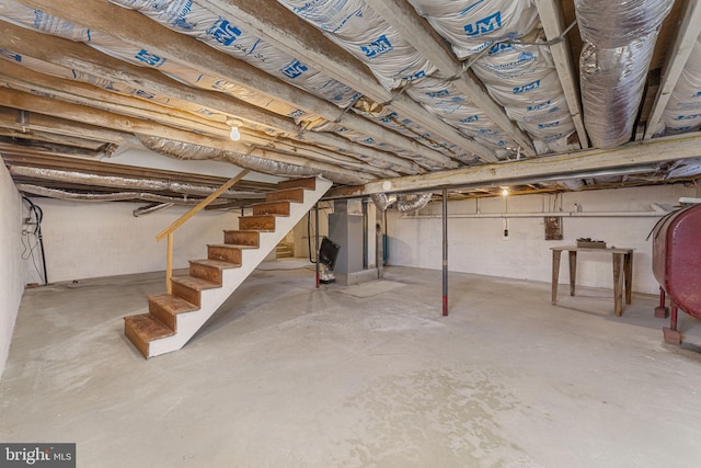 unfinished basement with stairway and heating fuel