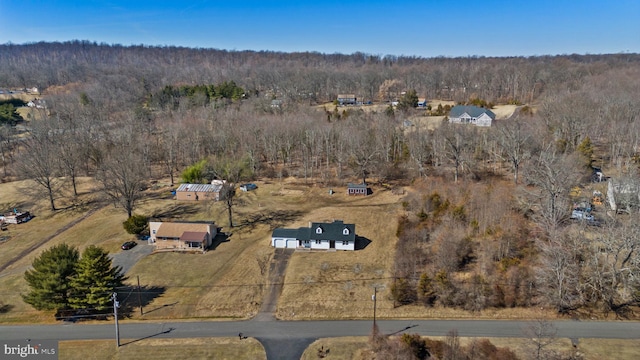 drone / aerial view featuring a wooded view