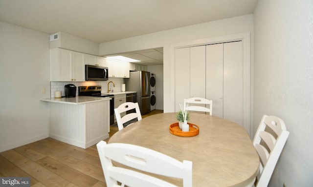 dining room with light wood finished floors, visible vents, and a drop ceiling