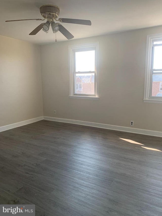 unfurnished room with ceiling fan, baseboards, and dark wood finished floors