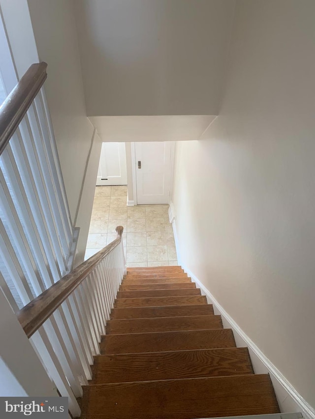 stairs featuring baseboards and tile patterned flooring