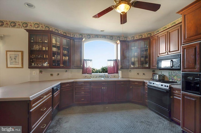 kitchen featuring range with gas stovetop, a peninsula, light countertops, and black microwave