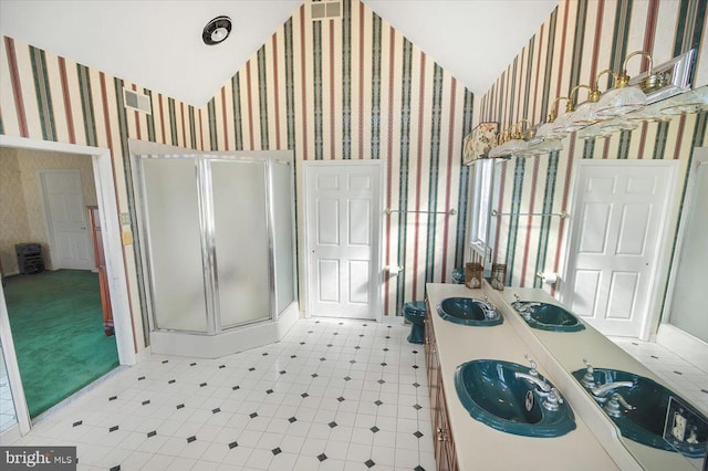 full bath featuring a shower stall, wallpapered walls, lofted ceiling, and a sink