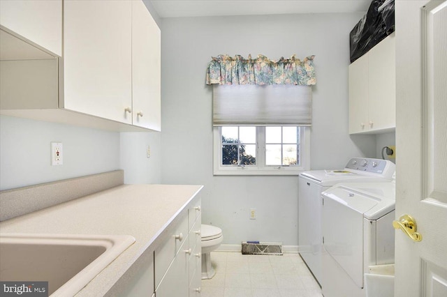 clothes washing area with washing machine and clothes dryer, cabinet space, baseboards, and a sink